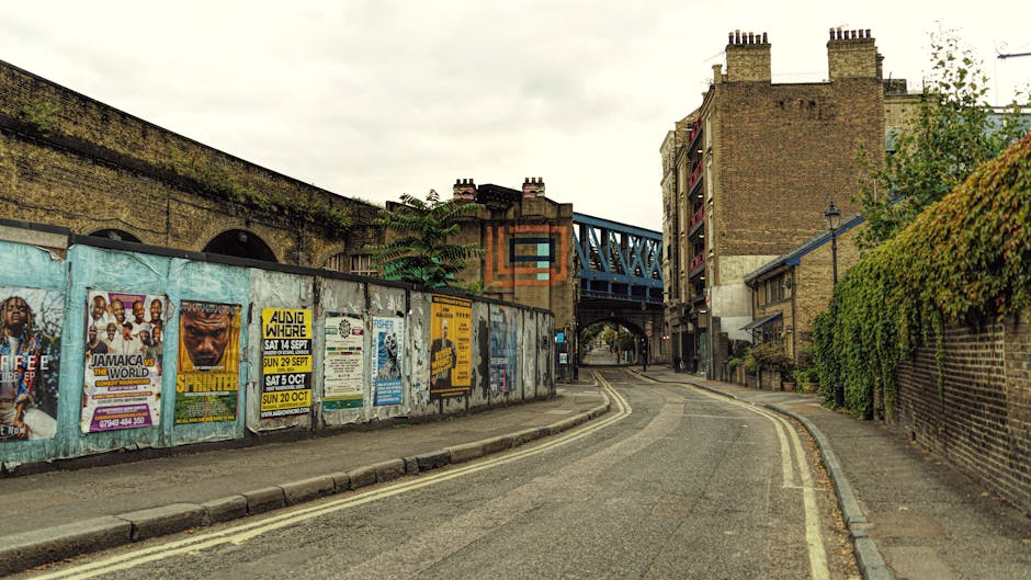 A street scene in Muswell Hill featuring multi-storey buildings with a mix of red brick and ornate architecture. In the foreground, a mid-sized light grey van operated by Man with Van Muswell Hill is